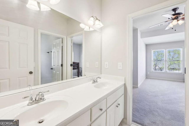 bathroom featuring baseboards, double vanity, a sink, and a ceiling fan