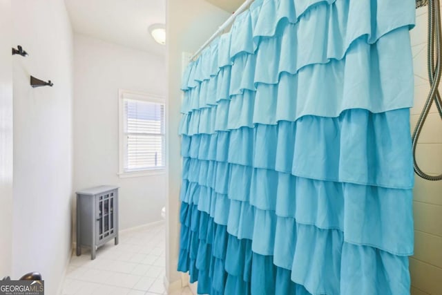 bathroom with a shower with curtain and tile patterned flooring