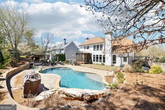 view of swimming pool featuring a fenced in pool, a sunroom, fence, and a patio