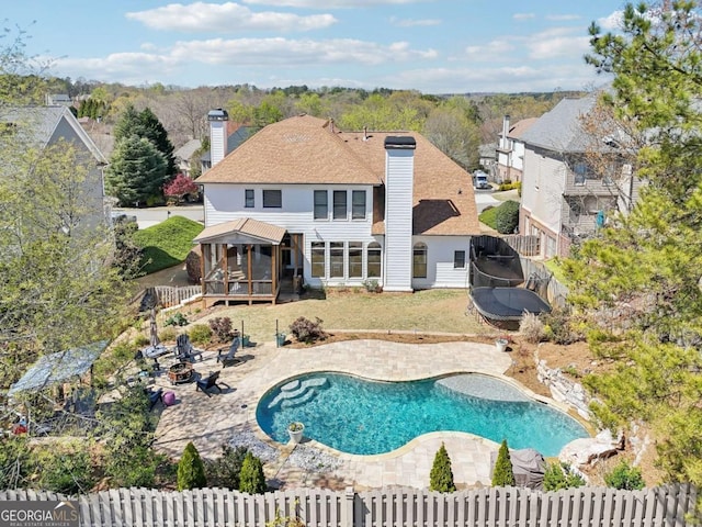 view of pool with a sunroom, a fenced in pool, a fenced backyard, and a patio area