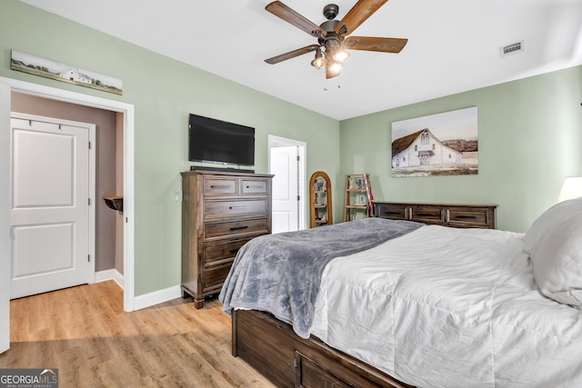 bedroom with baseboards, ceiling fan, visible vents, and light wood-style floors