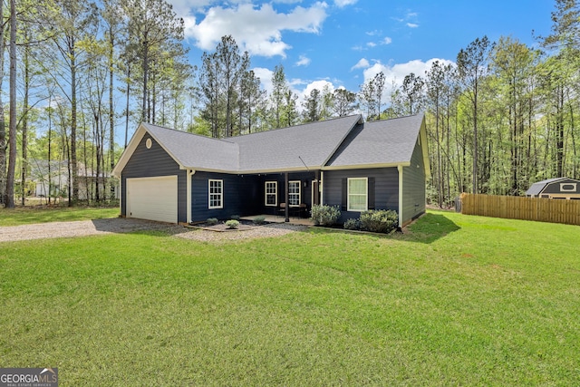 ranch-style home featuring fence, gravel driveway, an attached garage, a front yard, and a shingled roof