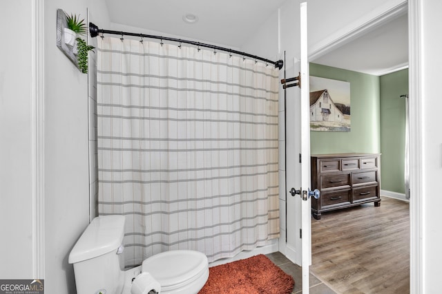 bathroom with toilet, a shower with shower curtain, and wood finished floors