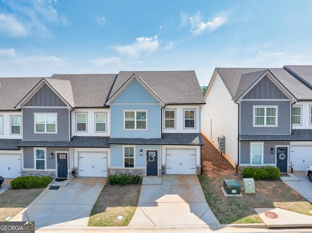 townhome / multi-family property featuring board and batten siding, stone siding, and concrete driveway
