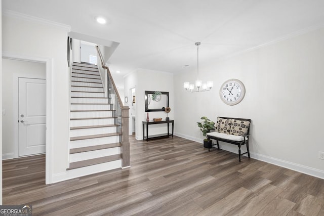 stairs with wood finished floors, an inviting chandelier, baseboards, ornamental molding, and recessed lighting