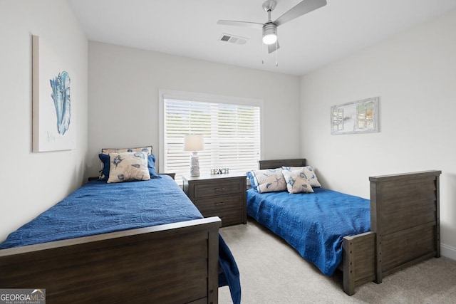 bedroom with visible vents, a ceiling fan, and light carpet