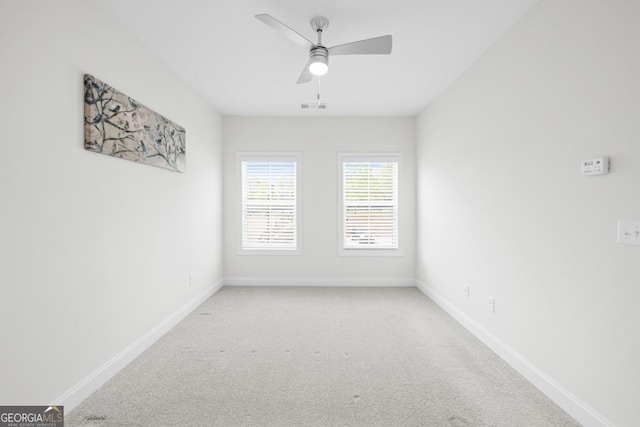 spare room featuring baseboards, visible vents, carpet, and ceiling fan