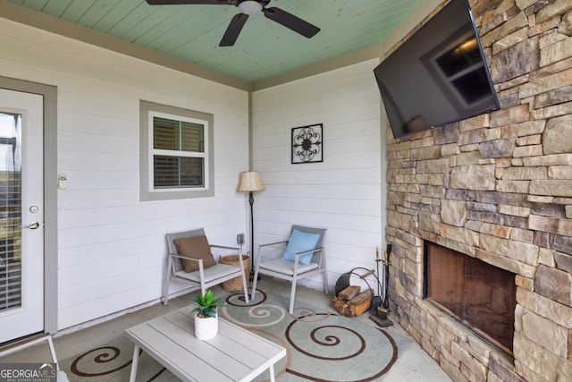 view of patio with an outdoor stone fireplace and ceiling fan