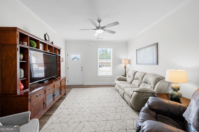 living area featuring baseboards, a ceiling fan, wood finished floors, and crown molding