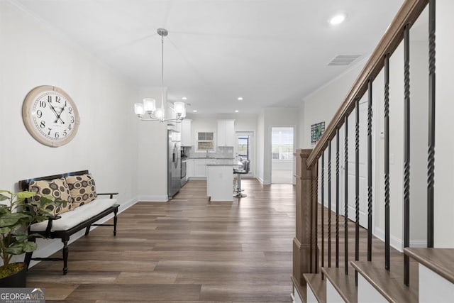 entrance foyer featuring stairway, visible vents, crown molding, and wood finished floors