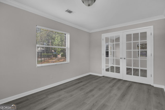 spare room with ornamental molding, french doors, baseboards, and wood finished floors