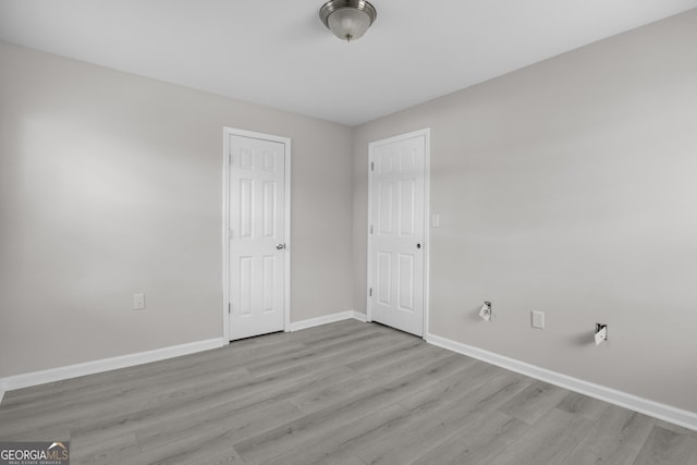 unfurnished bedroom with wood finished floors and baseboards