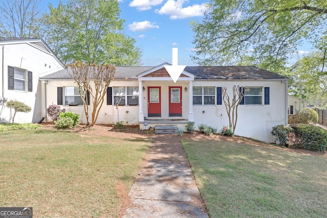 view of front facade with stucco siding and a front lawn