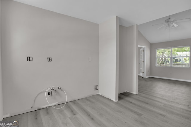 empty room with light wood-style floors, ceiling fan, baseboards, and vaulted ceiling