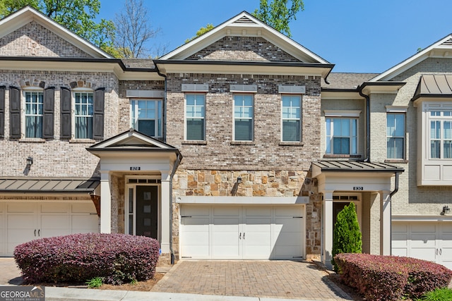 828 Canterbury Overlook NE, Atlanta, GA 30324 - view of property with a garage, a standing seam roof, brick siding, decorative driveway, and metal roof