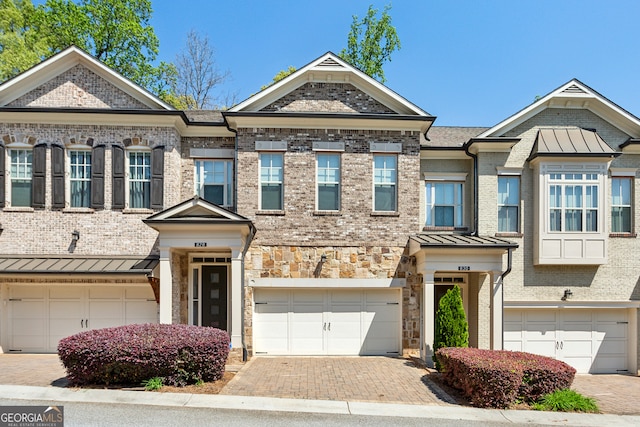 828 Canterbury Overlook NE, Atlanta, GA 30324 - view of property with a garage, a standing seam roof, decorative driveway, and brick siding