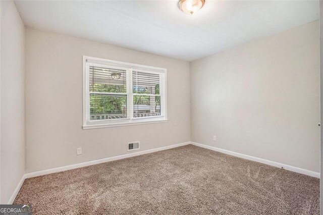 5052 Mountain St, Stone Mountain, GA 30083 - carpeted empty room with baseboards and visible vents