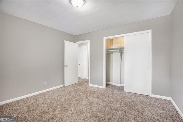 5052 Mountain St, Stone Mountain, GA 30083 - unfurnished bedroom with carpet floors, baseboards, and a closet