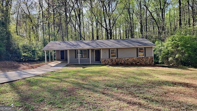 130 Fairview Dr, Stockbridge, GA 30281 - ranch-style home featuring stone siding, concrete driveway, a forest view, a front yard, and a carport