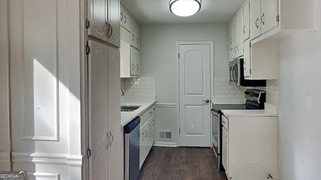 130 Fairview Dr, Stockbridge, GA 30281 - kitchen with stainless steel appliances, light countertops, dark wood-style flooring, and decorative backsplash