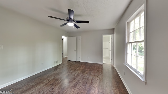 130 Fairview Dr, Stockbridge, GA 30281 - unfurnished bedroom with a textured ceiling, visible vents, baseboards, connected bathroom, and dark wood-type flooring