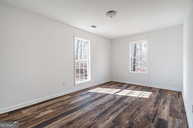 694 Austin Rd, Newnan, GA 30263 - empty room with dark wood-type flooring and a textured ceiling