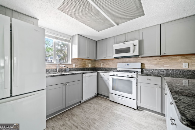 66 Fair Haven Way SE, Smyrna, GA 30080 - kitchen with light wood finished floors, white appliances, gray cabinets, dark stone counters, and visible vents