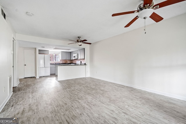 66 Fair Haven Way SE, Smyrna, GA 30080 - unfurnished living room featuring baseboards, a fireplace with flush hearth, a textured ceiling, and wood finished floors