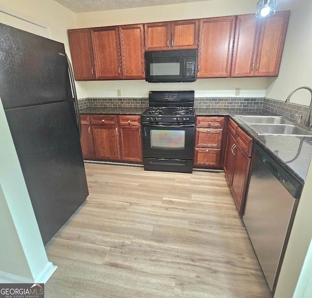 1557 Springleaf Ct SE, Smyrna, GA 30080 - kitchen with tasteful backsplash, light wood-style flooring, a sink, dark countertops, and black appliances
