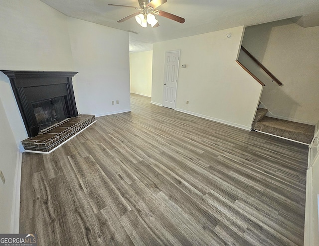 1557 Springleaf Ct SE, Smyrna, GA 30080 - unfurnished living room featuring stairway, wood finished floors, ceiling fan, and a fireplace with raised hearth