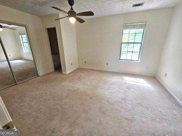 1557 Springleaf Ct SE, Smyrna, GA 30080 - unfurnished bedroom featuring a textured ceiling, visible vents, baseboards, and light carpet