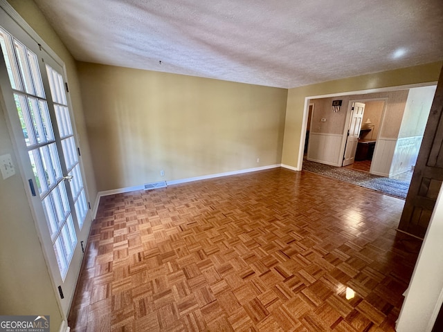 839 Golf Dr, Swainsboro, GA 30401 - empty room with a wainscoted wall, plenty of natural light, a textured ceiling, and visible vents