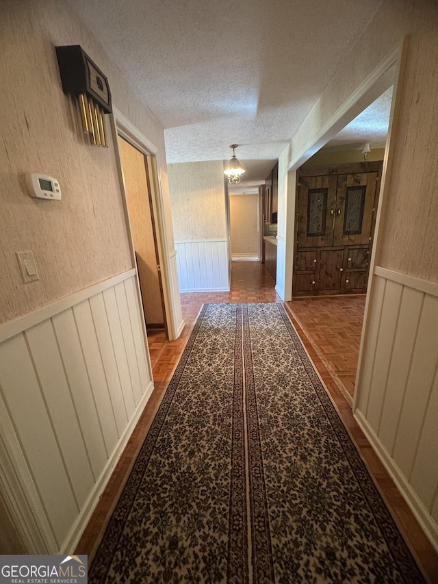 839 Golf Dr, Swainsboro, GA 30401 - hallway featuring a wainscoted wall and a textured ceiling