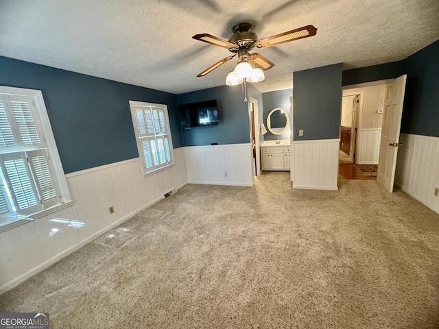 839 Golf Dr, Swainsboro, GA 30401 - interior space with a textured ceiling, ceiling fan, wainscoting, and carpet