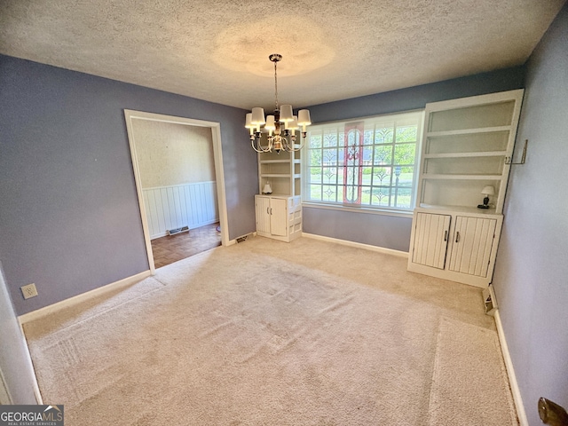 839 Golf Dr, Swainsboro, GA 30401 - unfurnished dining area with a textured ceiling, baseboards, and a notable chandelier
