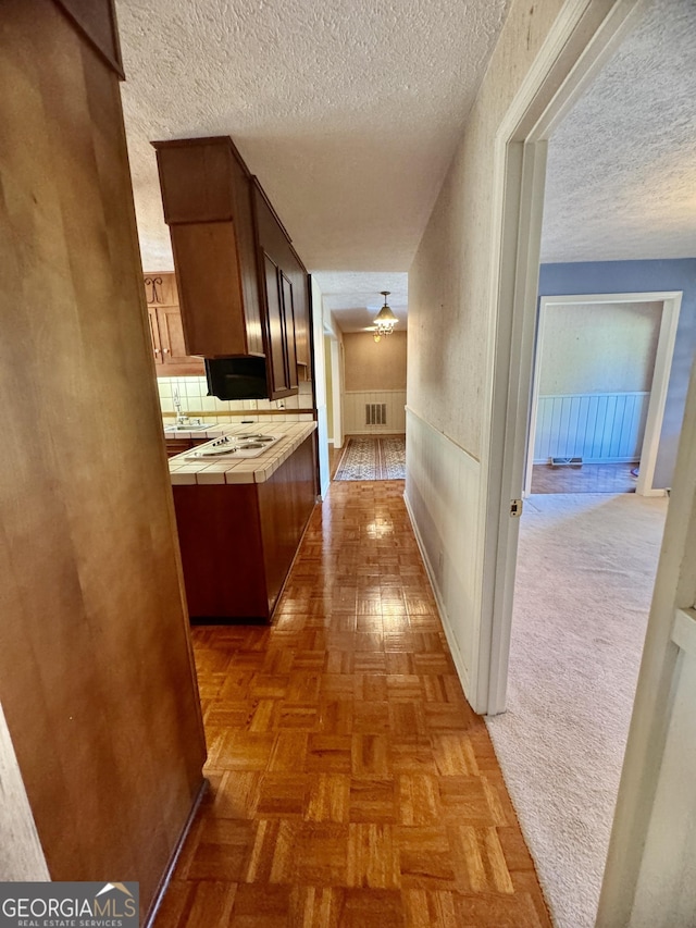 839 Golf Dr, Swainsboro, GA 30401 - hall featuring visible vents, a textured ceiling, and wainscoting