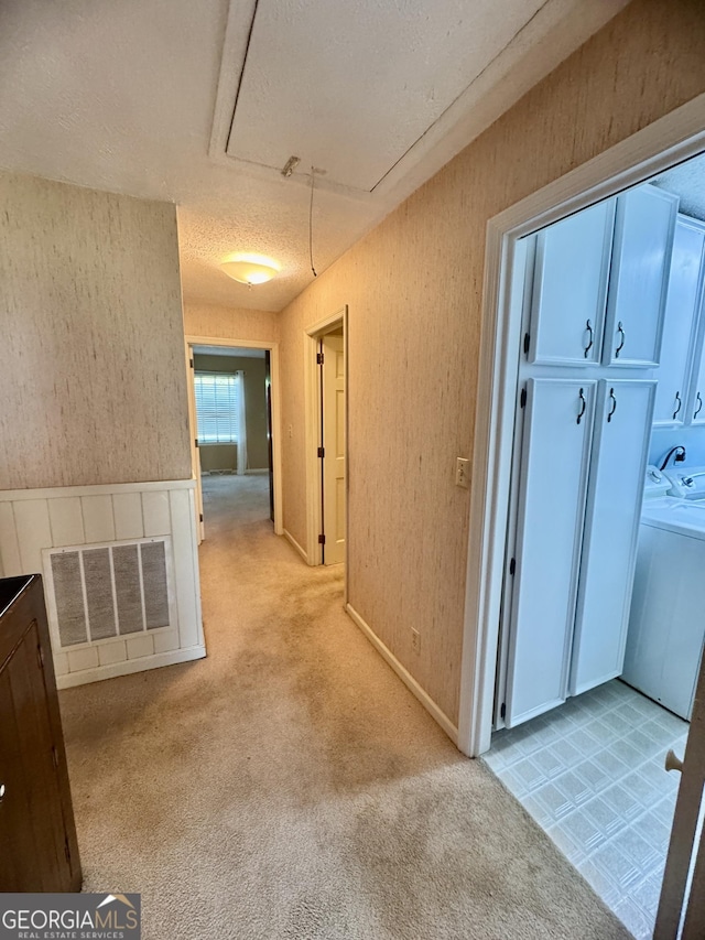 839 Golf Dr, Swainsboro, GA 30401 - hall featuring visible vents, washer and dryer, attic access, light colored carpet, and a textured ceiling