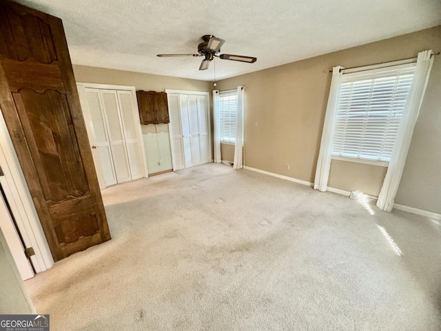 839 Golf Dr, Swainsboro, GA 30401 - unfurnished bedroom with light colored carpet, baseboards, and two closets