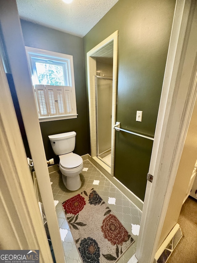 839 Golf Dr, Swainsboro, GA 30401 - full bathroom with a stall shower, toilet, a textured ceiling, and visible vents