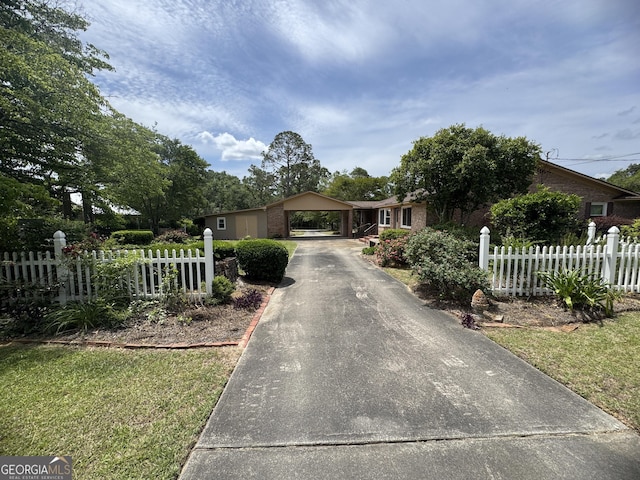 839 Golf Dr, Swainsboro, GA 30401 - view of front facade with a carport, a fenced front yard, driveway, and brick siding