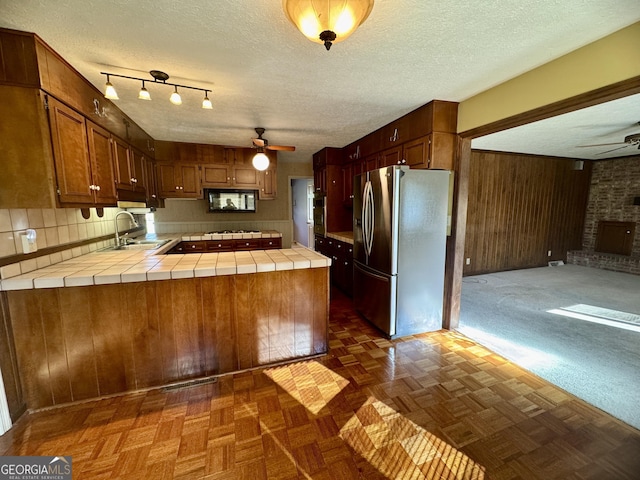 839 Golf Dr, Swainsboro, GA 30401 - kitchen with a peninsula, stainless steel fridge with ice dispenser, a ceiling fan, and tile countertops