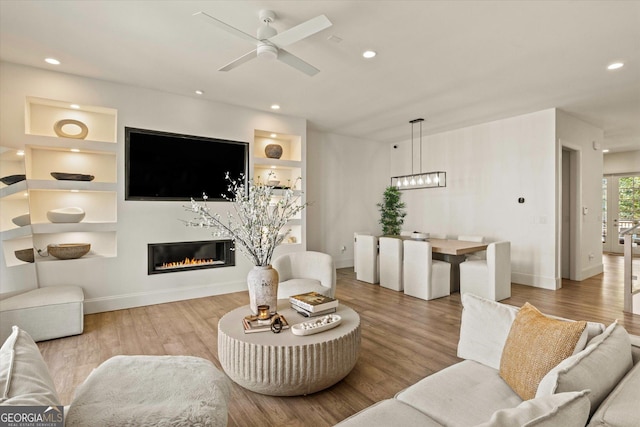 1337 Grey Fox Ct NE Unit 7, Atlanta, GA 30306 - living room with recessed lighting, baseboards, a glass covered fireplace, ceiling fan with notable chandelier, and wood finished floors