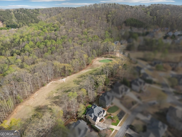 birds eye view of property featuring a wooded view