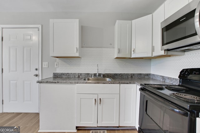 944 Joseph E Boone Blvd NW, Atlanta, GA 30314 - kitchen with a sink, stainless steel microwave, white cabinetry, and electric range