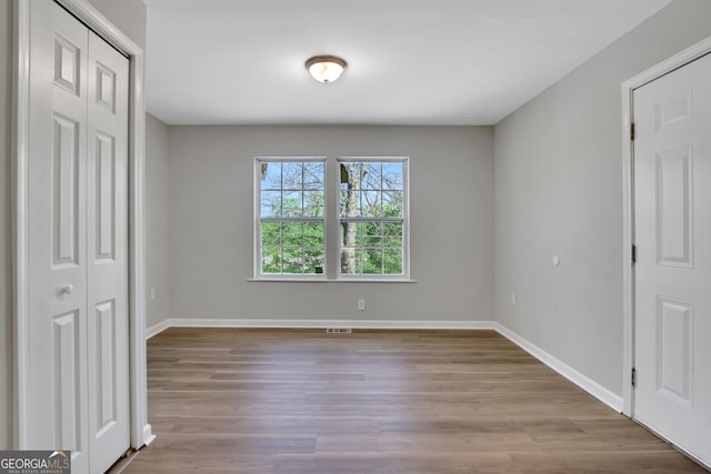 944 Joseph E Boone Blvd NW, Atlanta, GA 30314 - unfurnished bedroom with wood finished floors, baseboards, a closet, and visible vents
