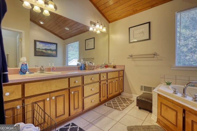 bathroom with a sink, vaulted ceiling, visible vents, and tile patterned floors