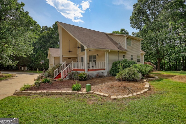 view of front of home with roof with shingles, driveway, a front yard, covered porch, and a ceiling fan
