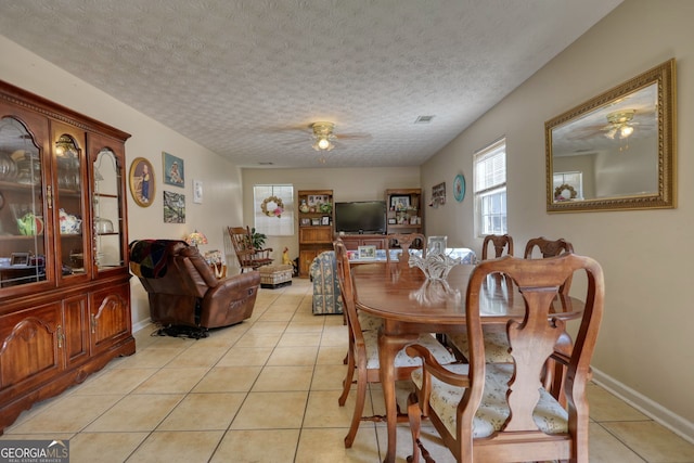 dining area with a textured ceiling, visible vents, light tile patterned floors, and a ceiling fan