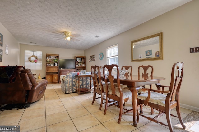 dining area featuring light tile patterned floors, a textured ceiling, visible vents, and a ceiling fan