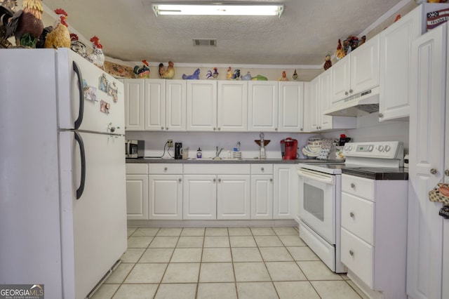 kitchen featuring white appliances, under cabinet range hood, a sink, dark countertops, and visible vents
